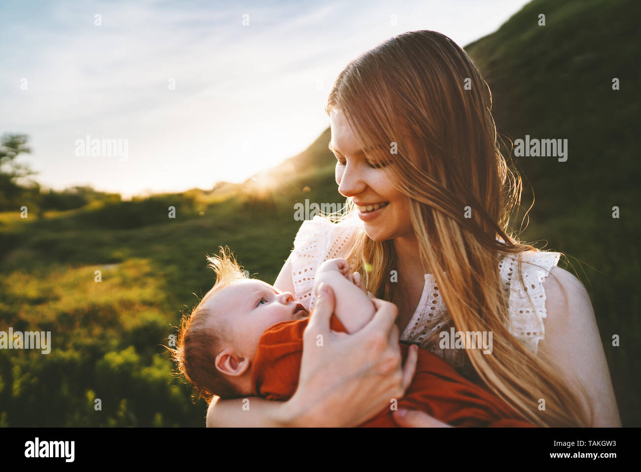 Madre camminando con un neonato bambino felice outdoor lifestyle famiglia mamma e bambino vacanze insieme maternità madri giorno Foto Stock