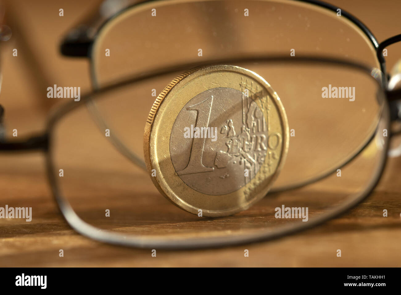 Concetto di risparmio accorta con un euro fotografato attraverso una coppia di specs Foto Stock