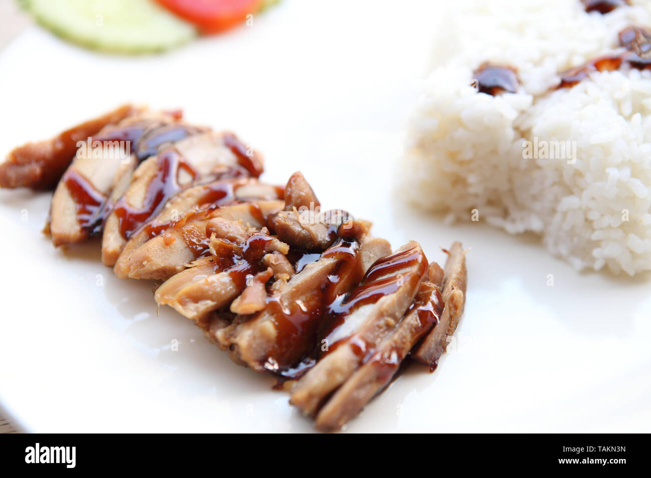 Pollo alla griglia teriyaki riso su uno sfondo di legno Foto Stock