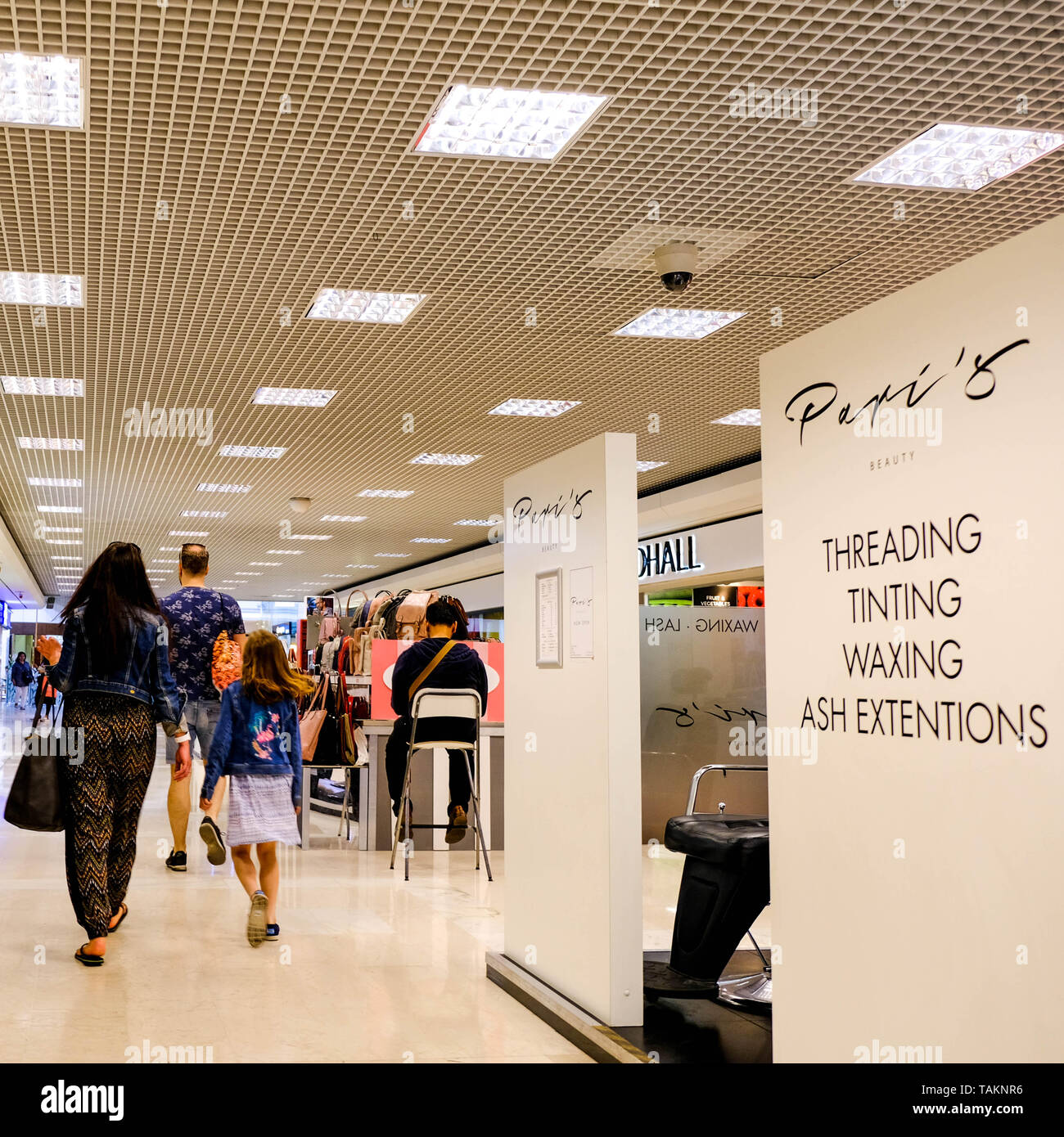 I consumatori a piedi attraverso un tranquillo centro commerciale per lo Shopping Foto Stock
