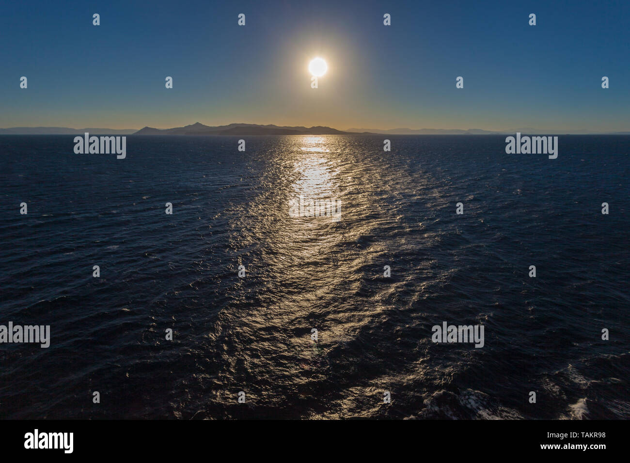 I riflessi del sole sul mare delle isole di salumi e di Egina in background nin il Golfo Saronico, Grecia Foto Stock