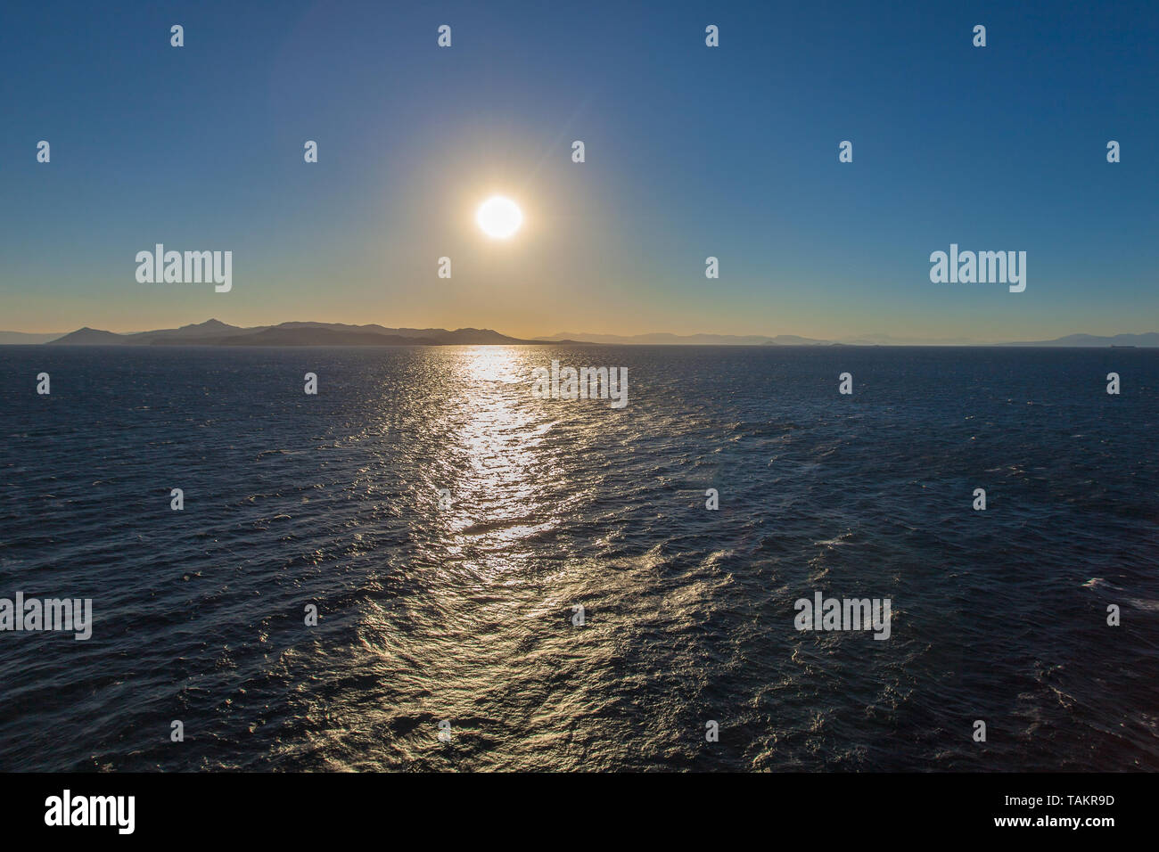 I riflessi del sole sul mare con navi e l'isola di Egina in background, Grecia Foto Stock
