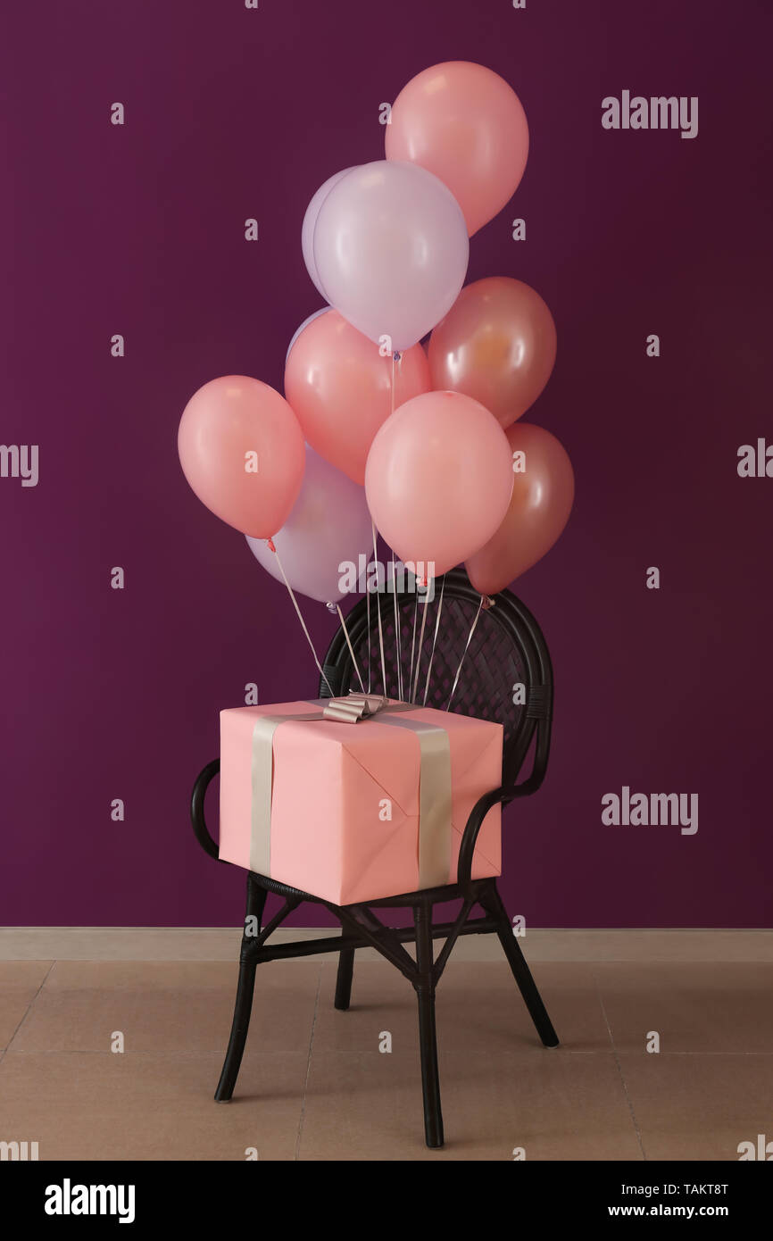 Sedia con palloncini di compleanno e confezione regalo in camera Foto stock  - Alamy
