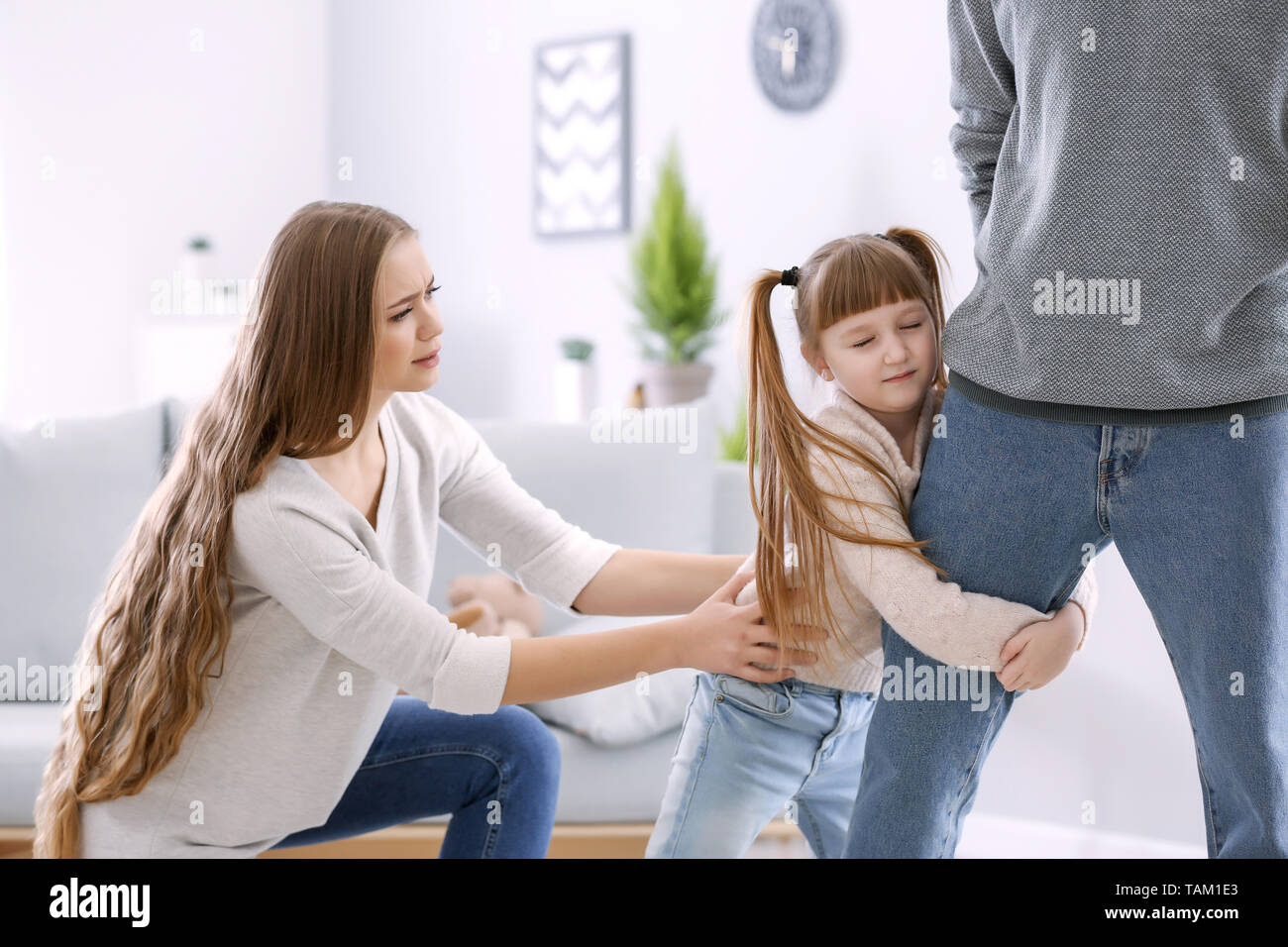 Bambina cercando di arrestare suo padre di lasciare la famiglia Foto Stock