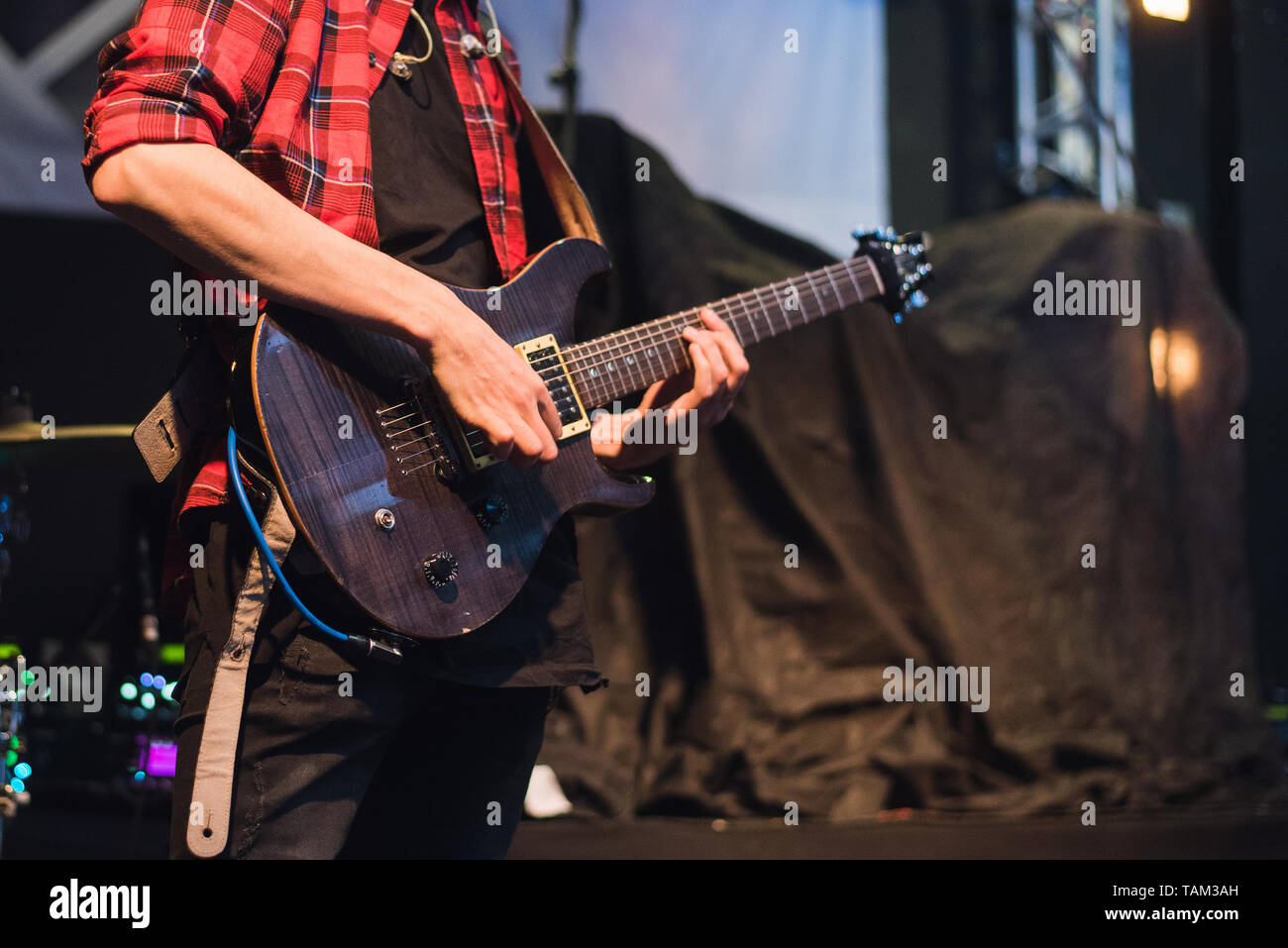 Chitarra elettrica nelle mani di un bilanciere. Un uomo suona la chitarra a un concerto rock. Foto Stock