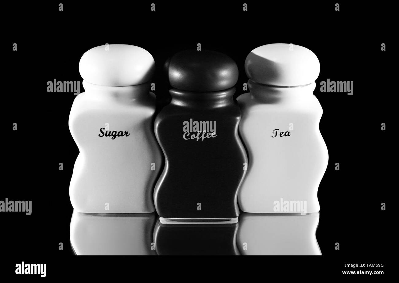 Capacità per il condimento spezie - zucchero, caffè, tè un set su uno sfondo nero. Foto Stock