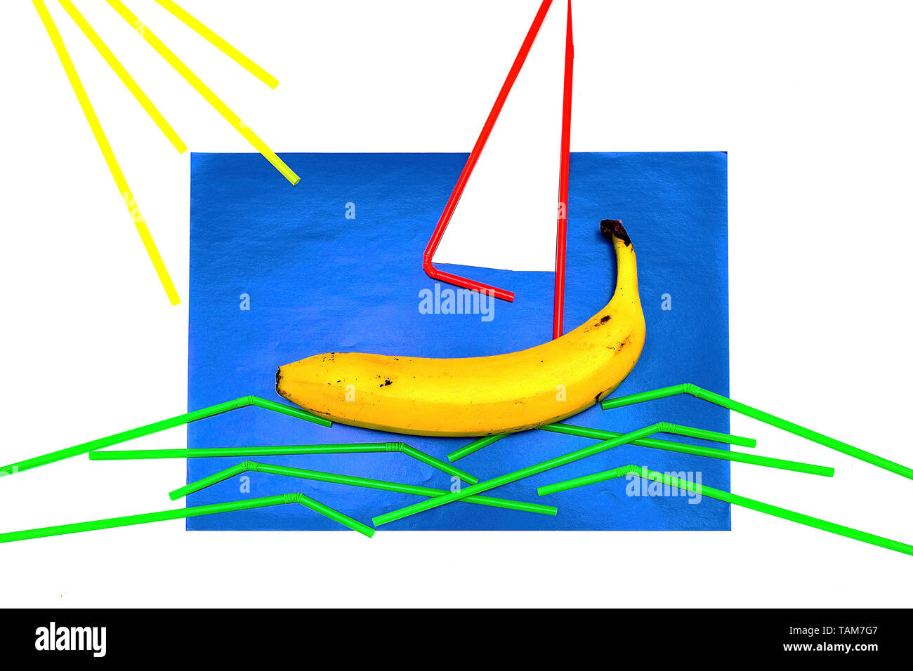 Banana, succhi di frutta con paglia su uno sfondo blu. La paglia si trova su uno sfondo blu a forma di vela e onde. La minima nozione di frutta dando il mio Foto Stock