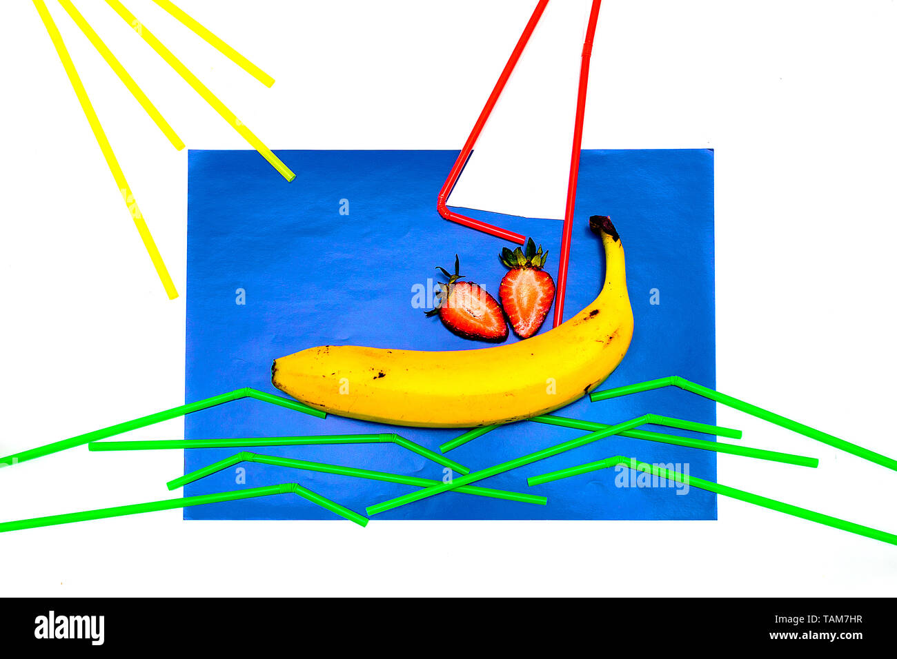 Banana, succhi di frutta con paglia su uno sfondo blu. La paglia si trova su uno sfondo blu a forma di vela e onde. La minima nozione di frutta dando il mio Foto Stock