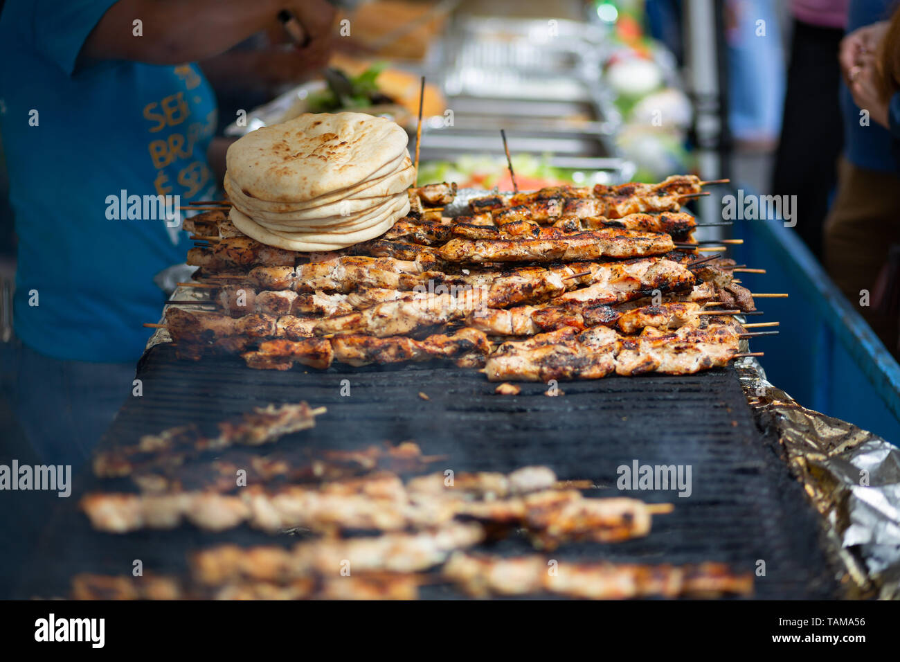 Spiedini di kebab di pollo e pane pita che cuociono su un grill in un mercato di strada a New York City, USA. Foto Stock