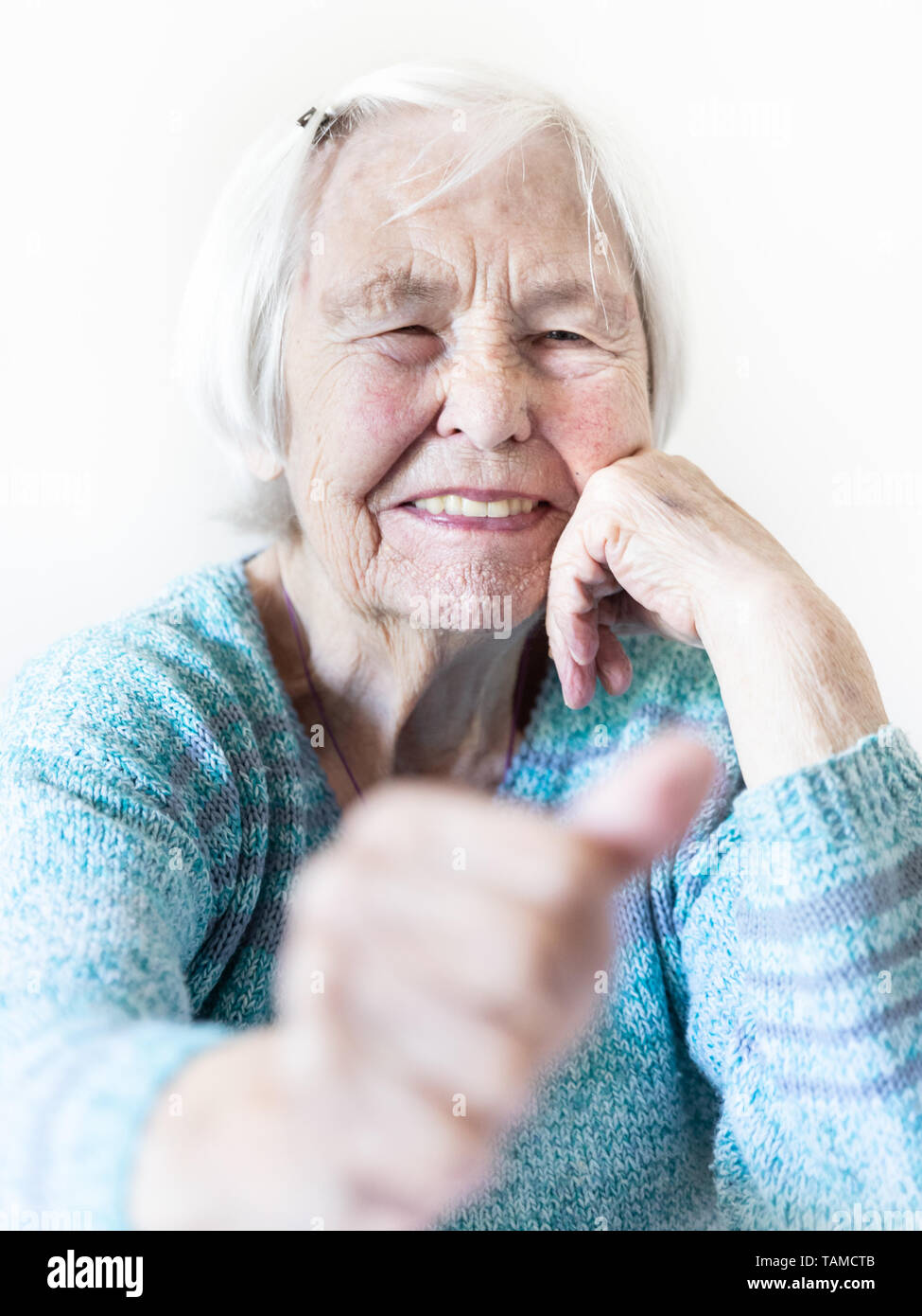 Happy 96 anni donna anziana dando un pollice in alto e guardando la fotocamera. Foto Stock