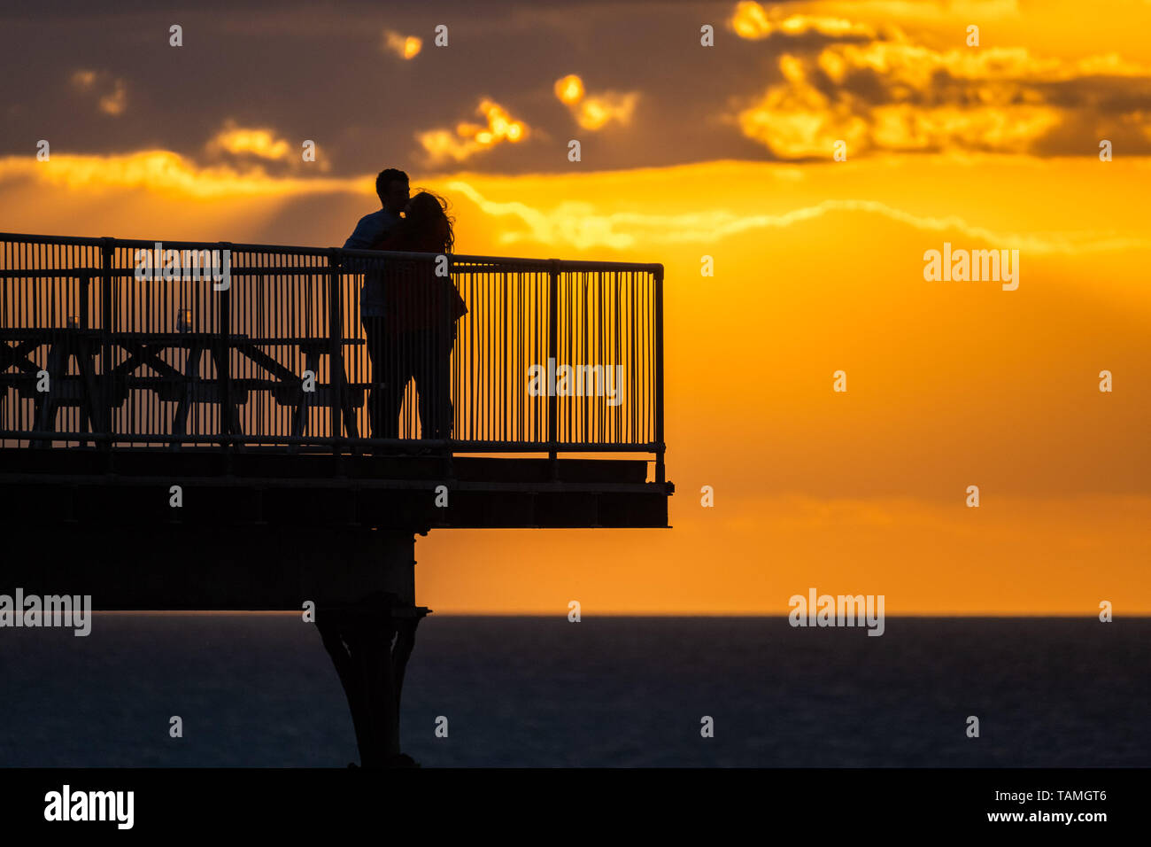 Aberystwyth Wales UK, domenica 26 maggio 2019 UK Meteo: un paio stagliano al tramonto sul molo di Aberystwyth in una fresca serata di maggio alla fine di una giornata di Pesanti rovesci e lunga magie di sole primaverile sulla costa occidentale del Galles. Domani, lunedì festivo, è prevista per essere un giorno di condizioni miste, con il rischio di pesanti thundery docce e una fresca brezza Photo credit: Keith Morris / Alamy Live News Foto Stock