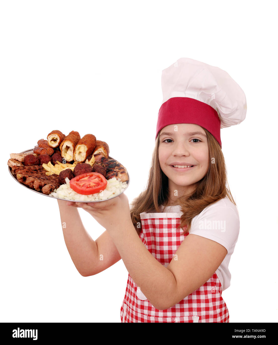 Felice bambina cook con grigliata mista di carne Foto Stock