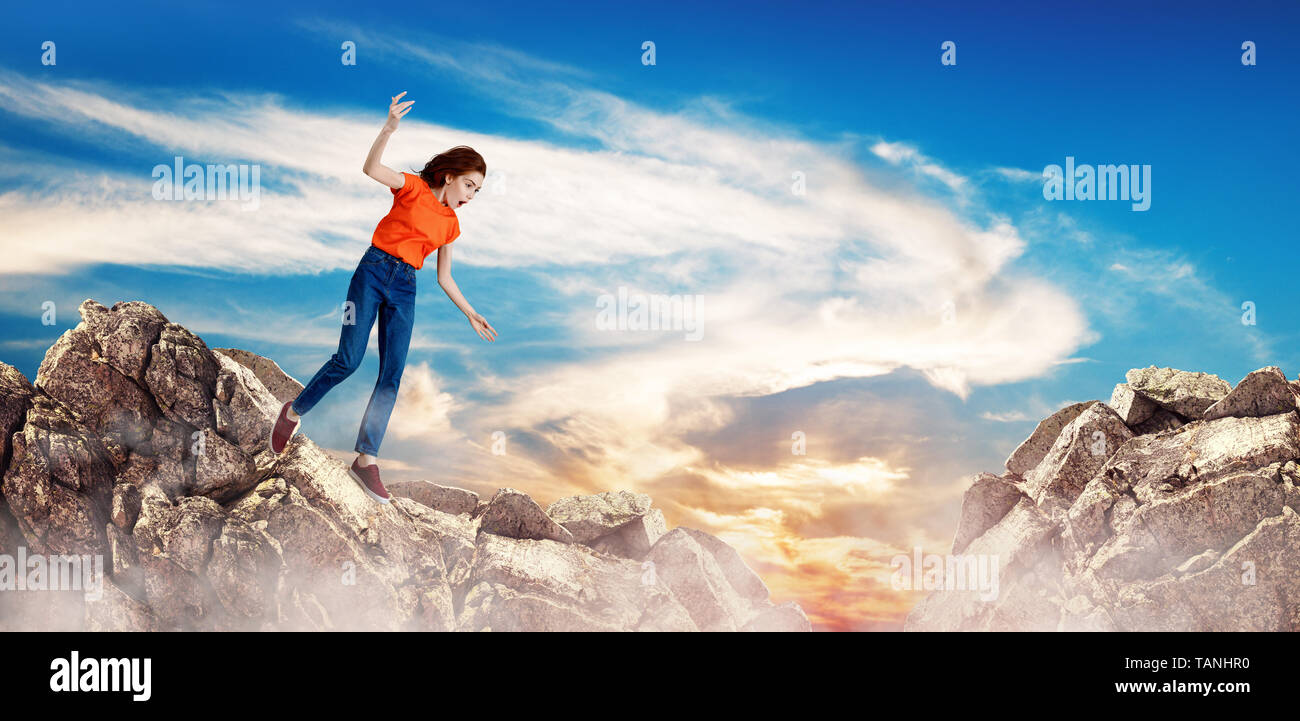 Redhead donna cadere tra le colline sulla scogliera. Foto Stock