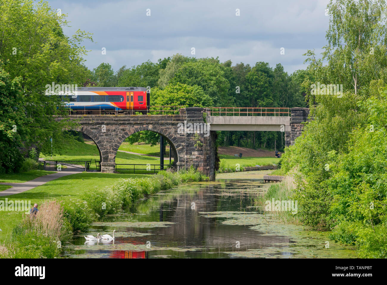 Il treno attraversa ponte sopra il Sankey canal in Sankey Valley Park. Foto Stock