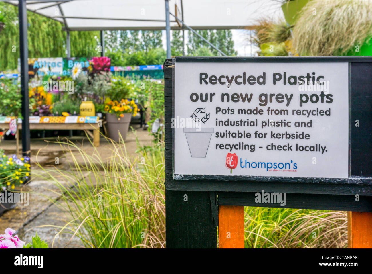 Segno ad un centro giardino pubblicizza riciclabile plastica grigio fioriere composto da materiali riciclati industriale in plastica che può essere riciclata stessi. Foto Stock