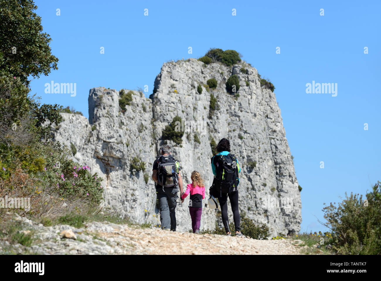 Famiglia Walkers, un paio & figlia ammirare le Rocher des Deux Trous nell'Area Caumes delle Colline Alpiles o Parco Regionale Provence Francia Foto Stock