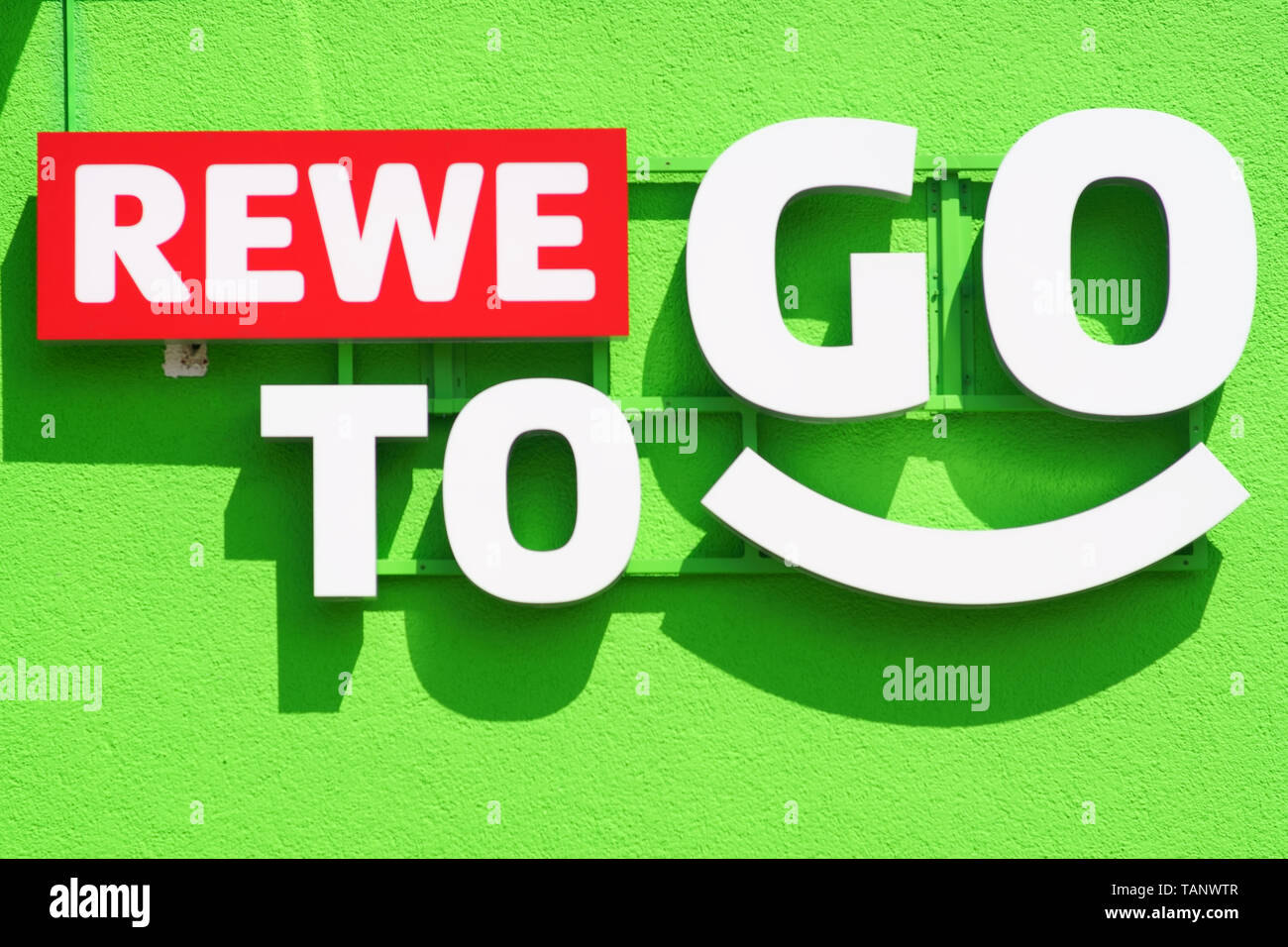 Nieder-Olm, Germania - 26 Maggio 2019: il logo stridulo del mercato alimentare REWE per andare su una moderna facciata esterna di una stazione di gas il 26 maggio 2019 in Nied Foto Stock