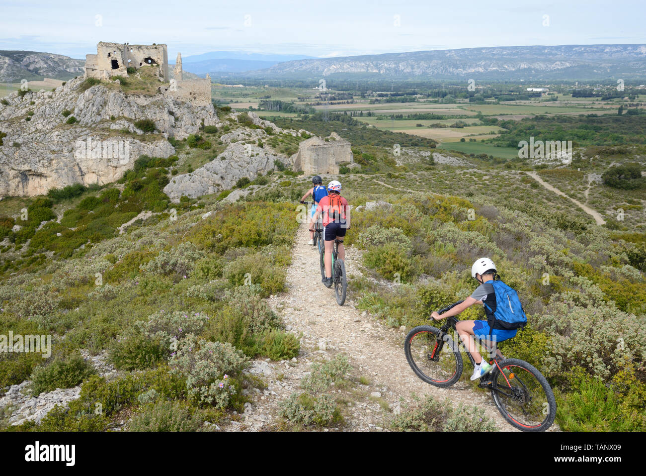 Tre giovani ragazzi Mountain Bike & Château de Roquemartine Les Alpilles Provenza Francia Foto Stock