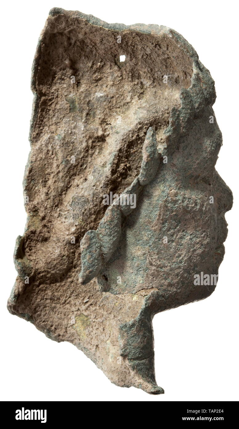 Una testa romana di un Africano maschio con funzioni di negroid, 2° - 3° secolo frammento di un bronzo balsamarium. Completamente preservato la faccia di un uomo nero con vetro intarsiato di allievi. Anche il rame intarsi in corrispondenza dei bordi delle labbra. Intorno al collo una scanalatura che ha tenuto il materiale ad inserti per il ruolo di una collana. Ampia naso e grandi labbra. Grossolanamente capelli modellato. Sulla parte superiore sinistra di un a palmette, sul quale l'anello della maniglia mancante è stato saldato. Superficie leggermente corroso. Bene anche oliva-patina verde. Altezza 10,5 cm. Lo stile eccellente di alta qualità con distintivi po, Additional-Rights-Clearance-Info-Not-Available Foto Stock