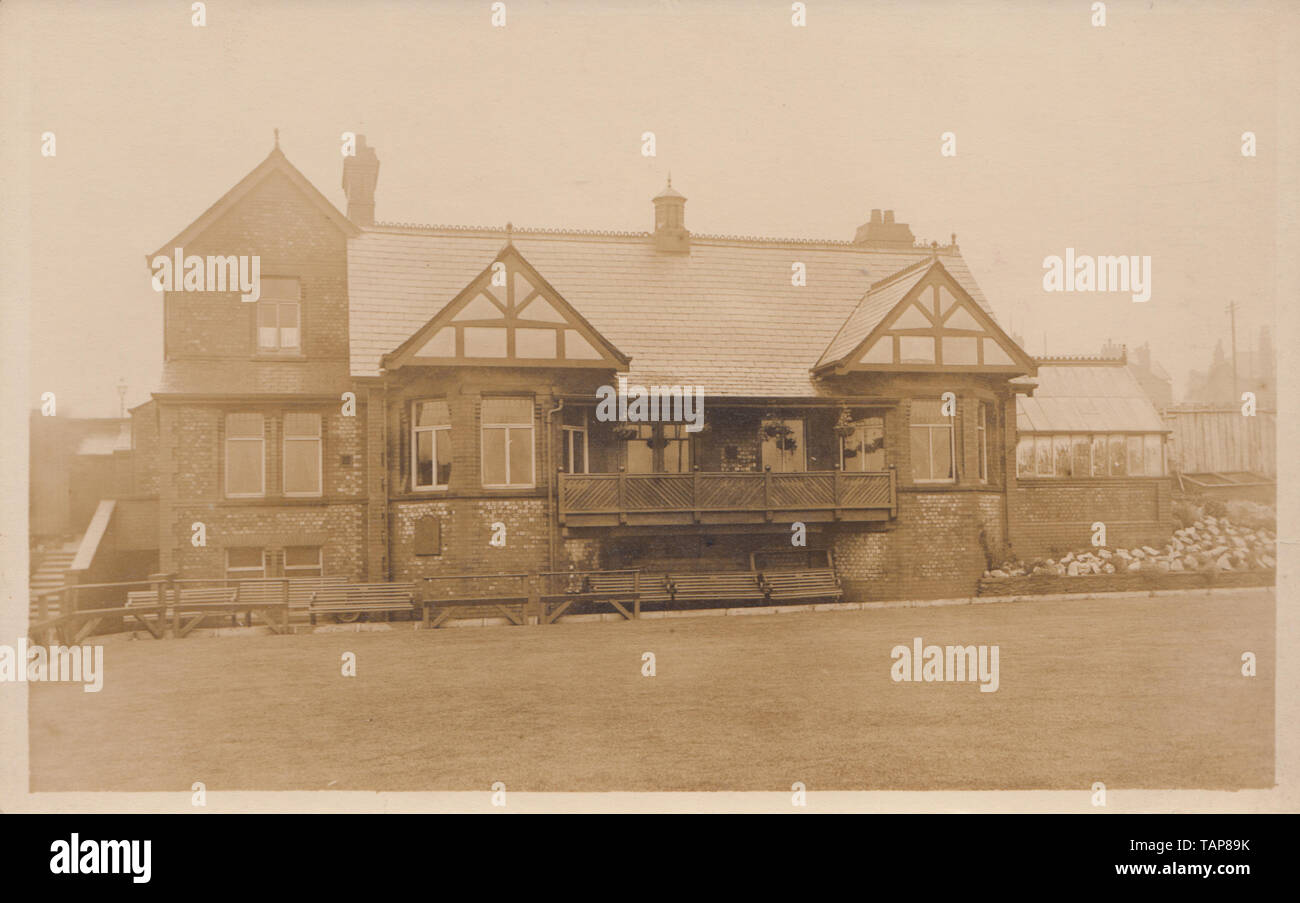 Vintage Cartolina fotografica che mostra una staccata edificio britannico. Eventualmente un bowling club e Bowling Green. Foto Stock