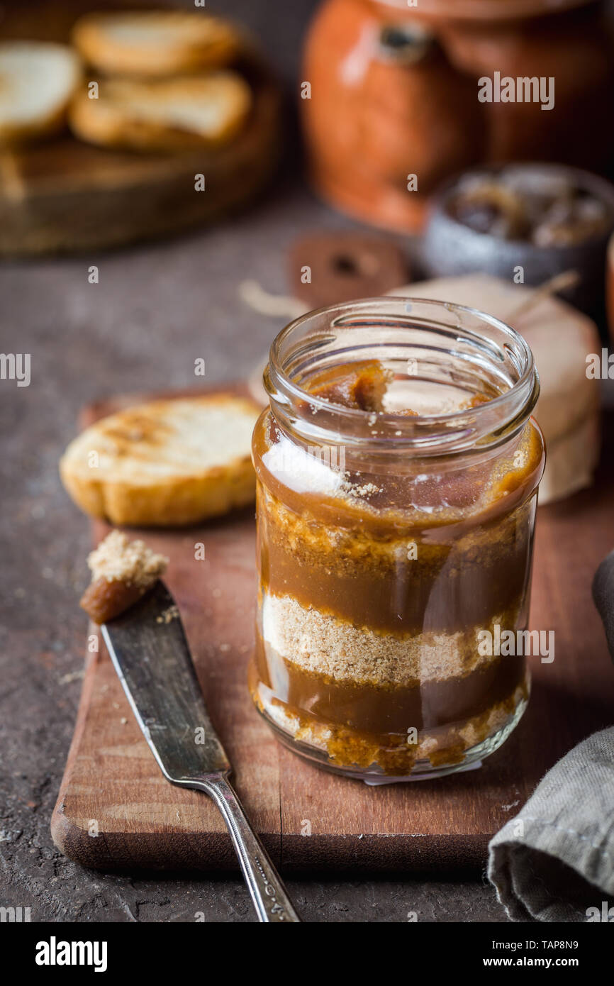 In casa salsa al caramello con i cookie in vaso su sfondo rustico. Foto Stock