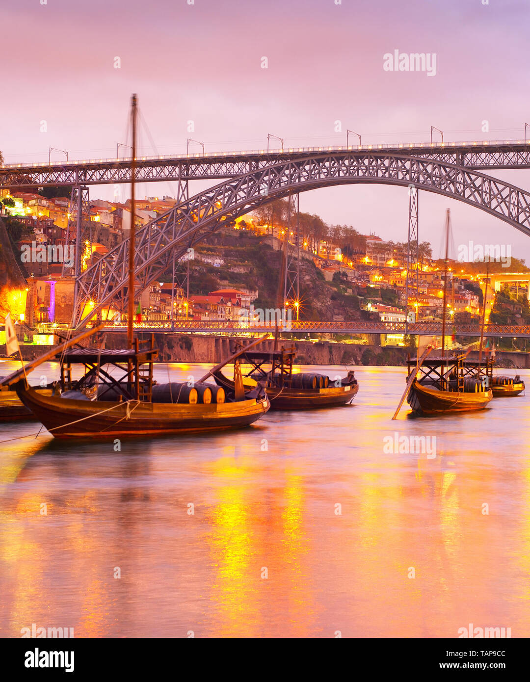 Scenic tramonto sul fiume Douro con vino tradizionale barche, illuminato Porto skyline e Dom Luis i bridge in background, Portogallo Foto Stock