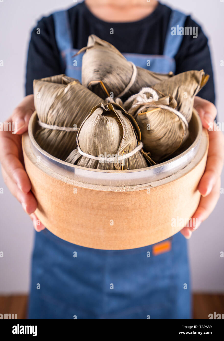 Zongzi, deliziosi cotti al vapore gnocchi di riso nel sistema di cottura a vapore in sfondo nero per il dragon boat festival duanwu, close up, copia spazio, vista dall'alto, laici piatta Foto Stock