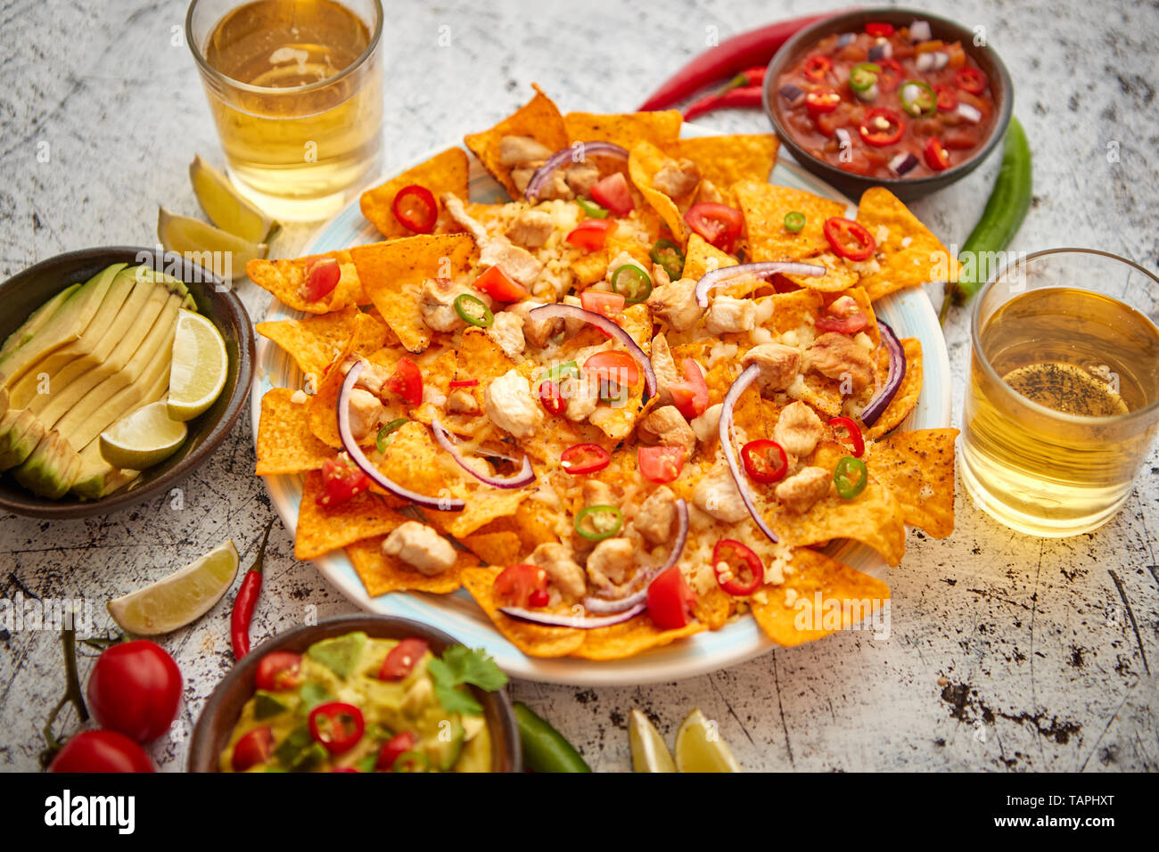 Mais Messicano nacho piccante di Patatine serviti con formaggio fuso, peperoni, pomodori, birra e lato salse. Foto Stock