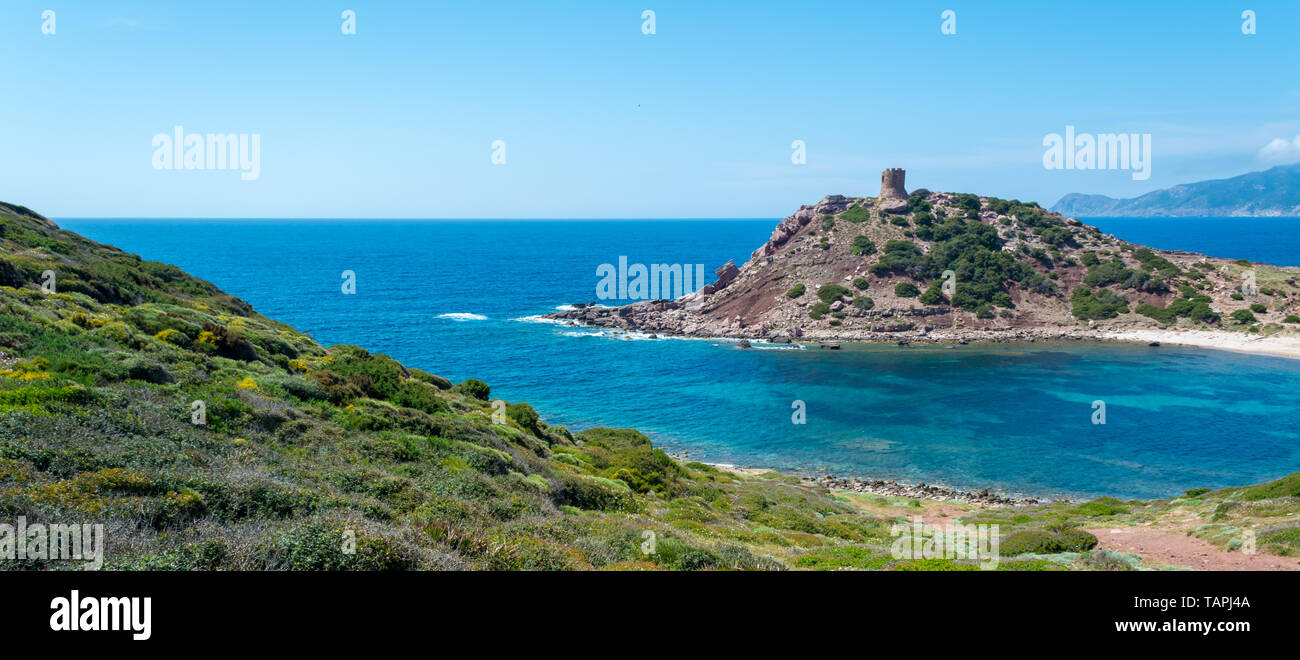 Il paesaggio della costa vicino al porticciolo, in Sardegna, con l'antica torre in una giornata di sole Foto Stock