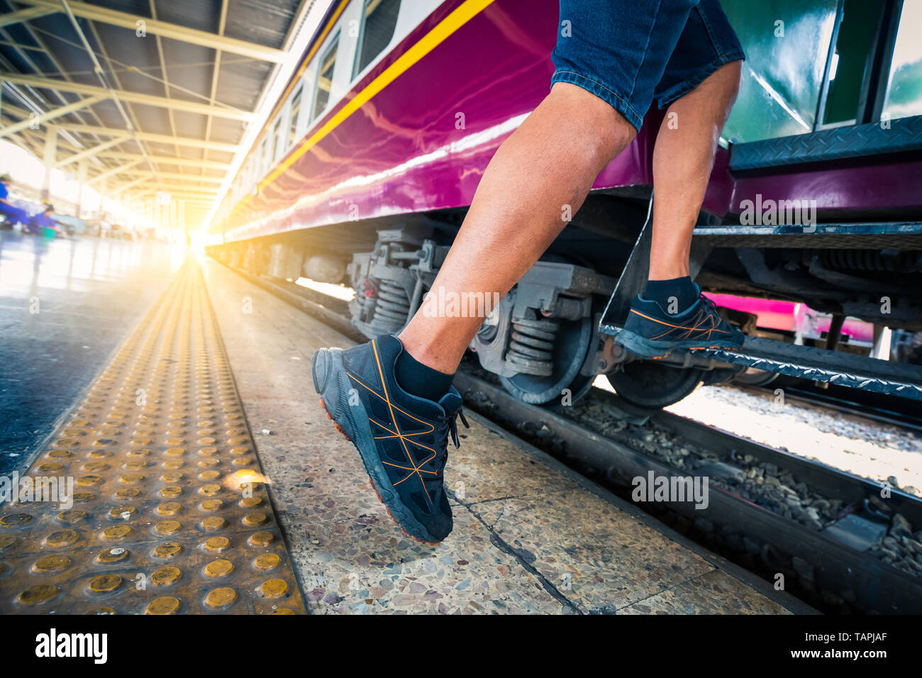 L'uomo viaggiatore con zaino di alzarsi con il treno alla stazione ferroviaria maschio backpacker viaggiare da solo . Foto Stock