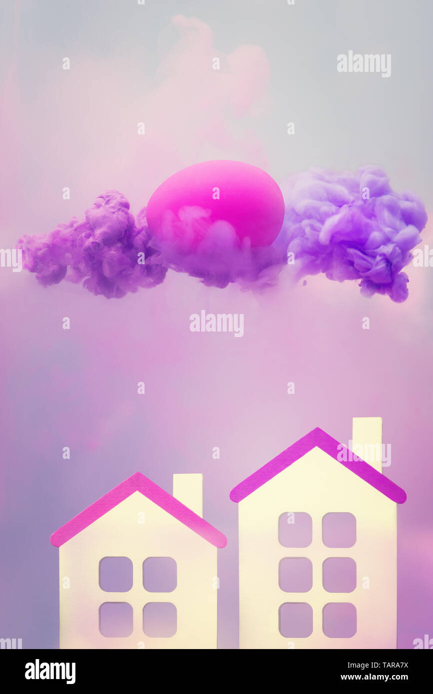 Fantasia surreale con due case e l'uovo in viola cloud di fluido Foto Stock