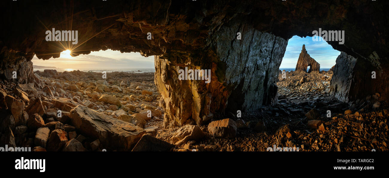 Panorama delle grotte su Playa de Campiecho costa rocciosa al tramonto, Asturias, Spagna Foto Stock