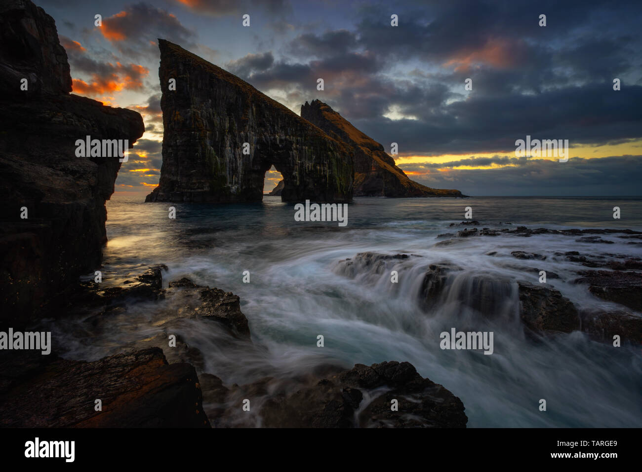 Drangarnir arco roccioso sul funzionario ministeriale isola nel tramonto, Isole Faerøer Foto Stock