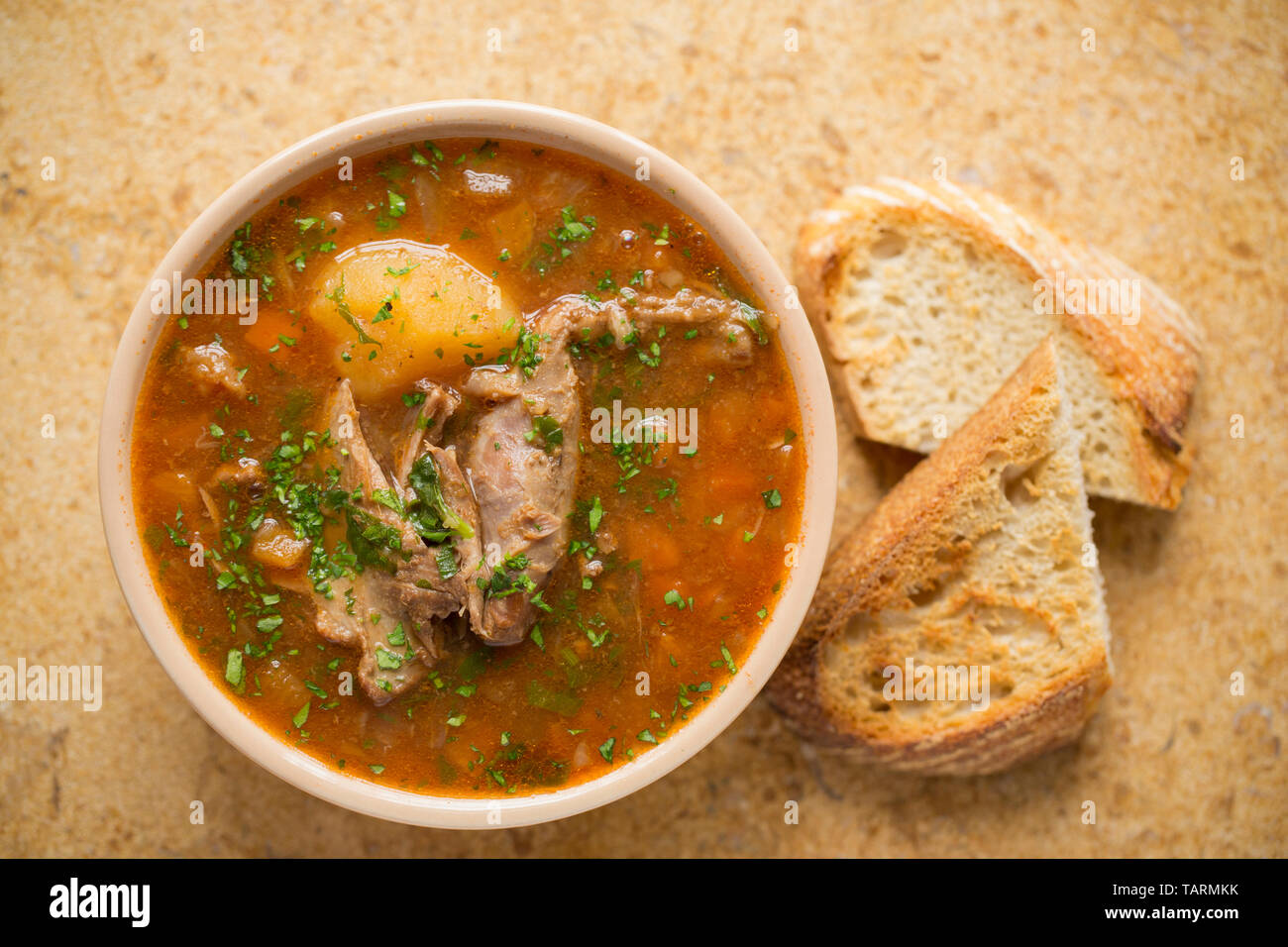 Una ciotola di carne di cervo in casa zuppa di slow-cucinato con carne di cervo carnosa le ossa che sono state composte in uno slow cooker con verdure, funghi e erbe per s Foto Stock