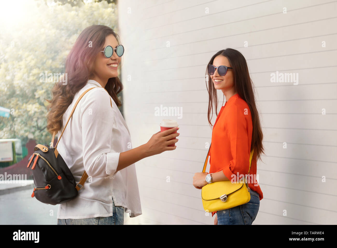 Donna passeggiate all'aperto con un amico azienda tazza da caffè Foto Stock