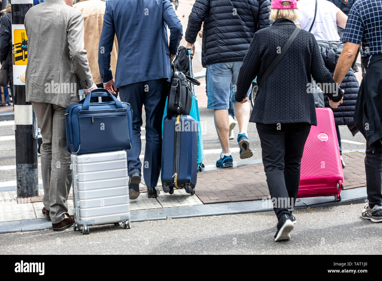 Turisti e visitatori con carrelli, in modo da e per la stazione ferroviaria di Amsterdam Centraal, Paesi Bassi, Foto Stock