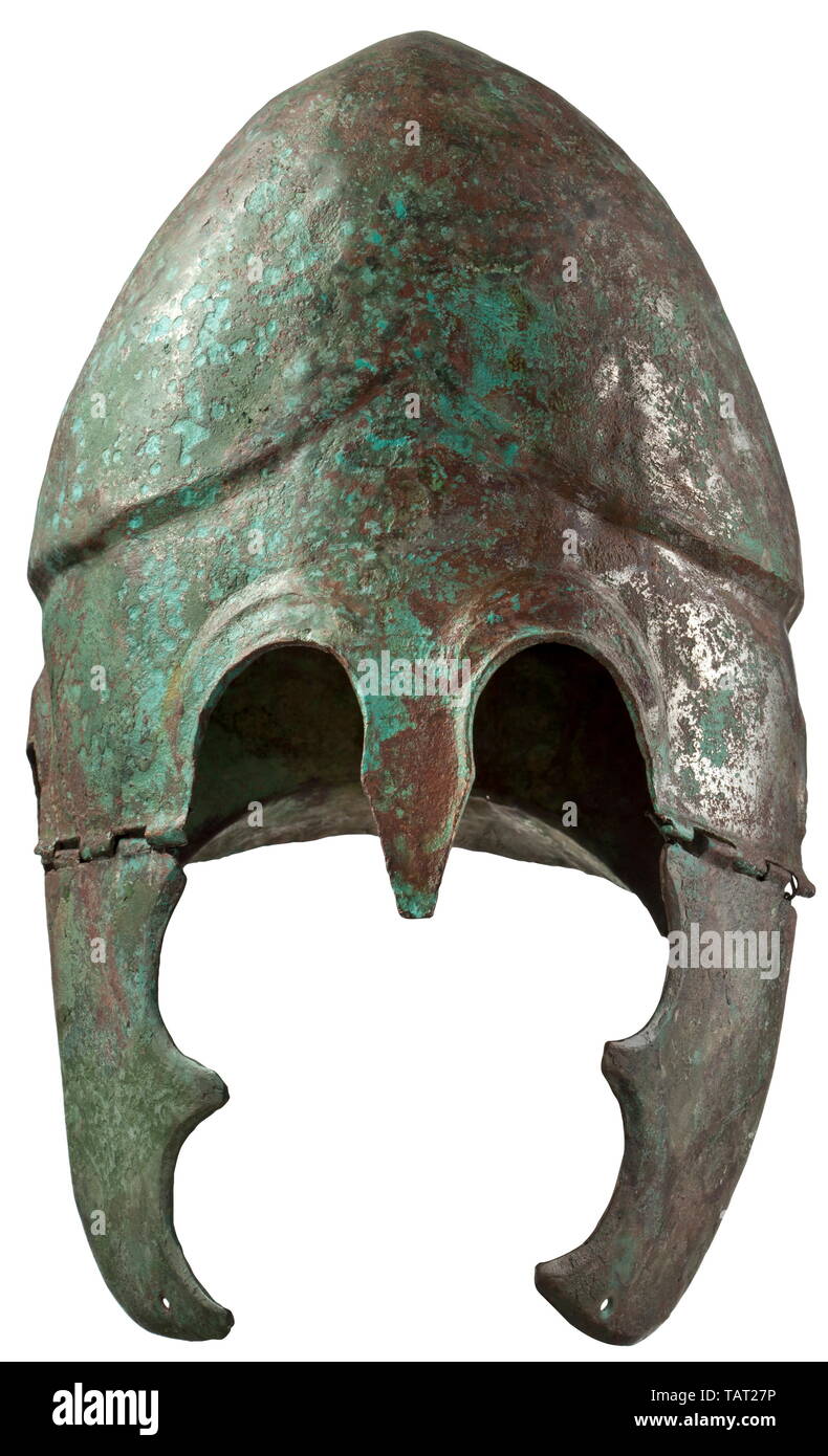 Un casco Chalcidian, tipo V, agli inizi del IV secolo A.C. casco di bronzo, in precedenza con full-di fronte la placcatura con stagno, in parte ancora conservate sul cranio e guancia pezzi. La parte mediale è decorata con nervature sagomate a L'occhio ed orecchio ritagli. Tra le sopracciglia una lancetta a forma di protezione naso. La sezione posteriore termina in una configurazione leggermente curva protezione collo separato su entrambi i lati da un piccolo fuller. Il teschio di alta è diviso in due lobi da una nervatura mediale e separati dalla parte mediale mediante una fase distinta rivolta verso l'alto sopra la fronte. La guancia pezzi wi, Additional-Rights-Clearance-Info-Not-Available Foto Stock