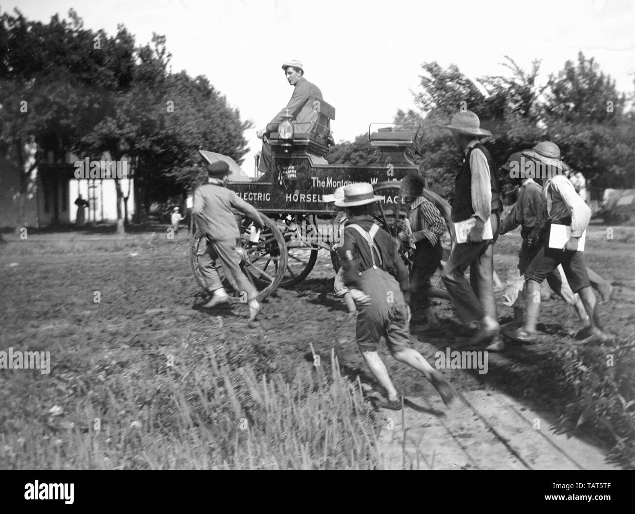 Scuola locale boys chase il Montgomery Ward Horseless carrello durante un tour d'America alla fermata in Olathe, Kansas nel 1897. Foto Stock