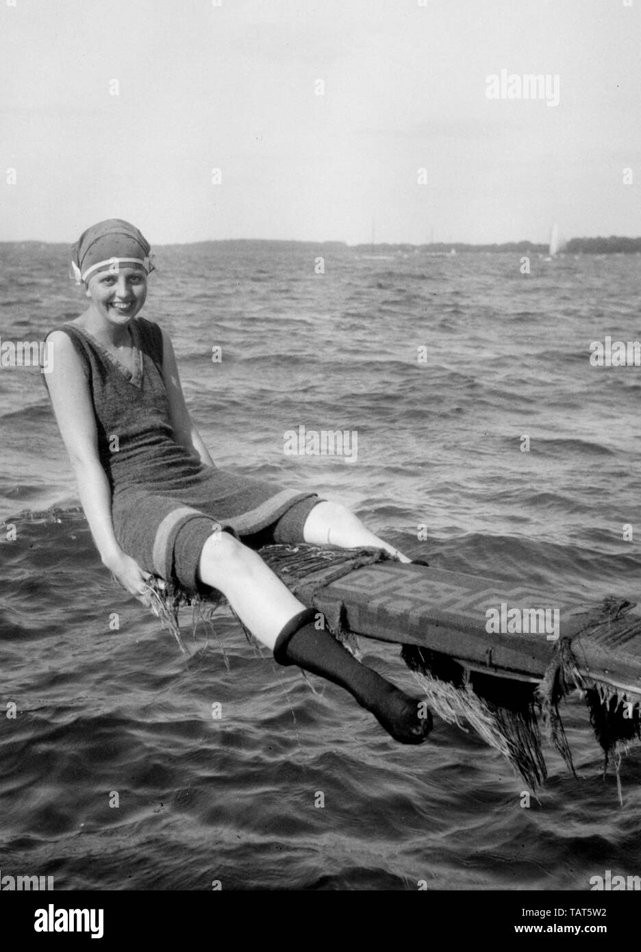Una giovane donna nel periodo swimwear pone lungo la riva del lago Mendota a Madison, Wisconsin, ca. 1925. Foto Stock
