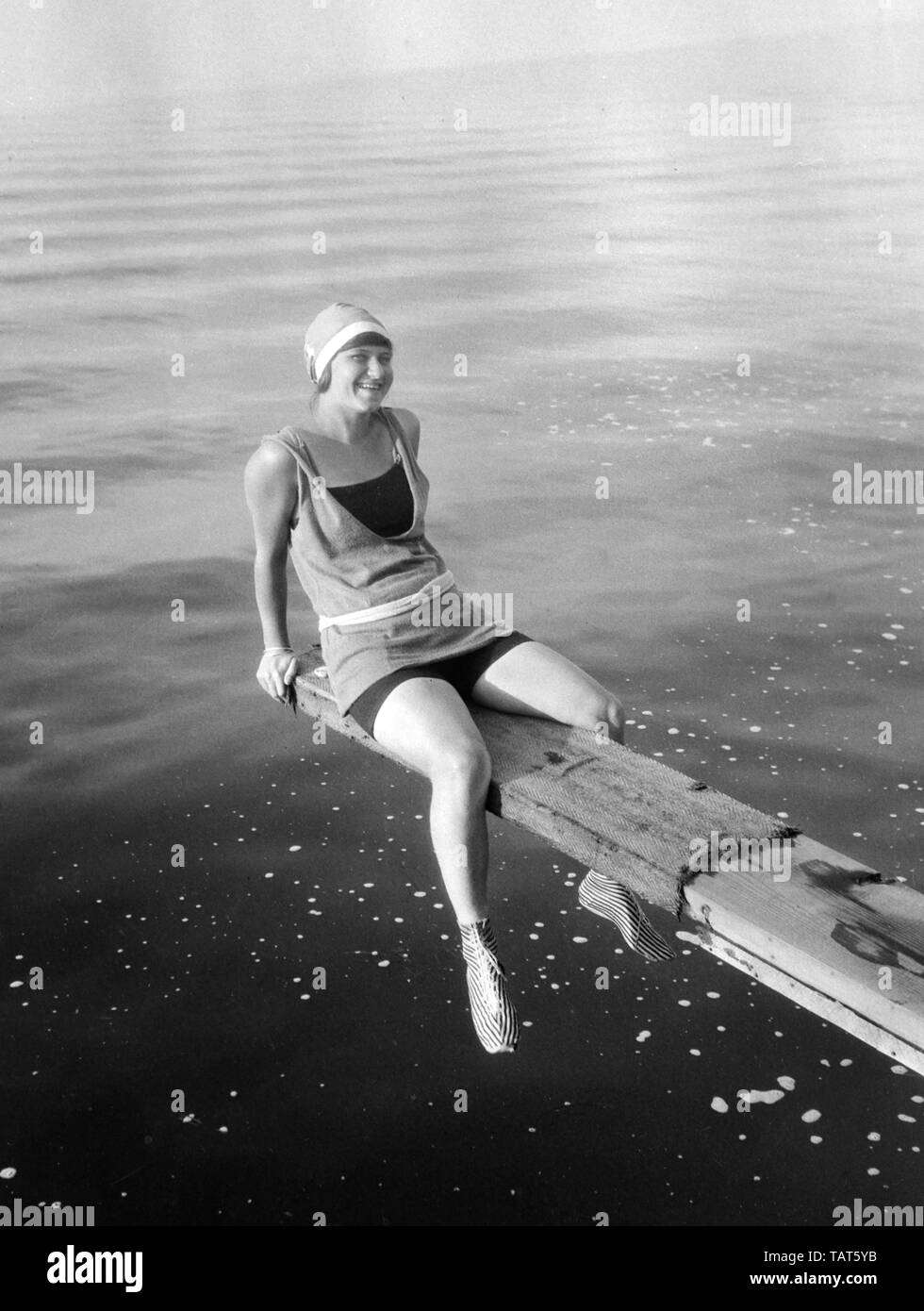 Una giovane donna nel periodo swimwear pone lungo la riva del lago Mendota a Madison, Wisconsin, ca. 1925. Foto Stock