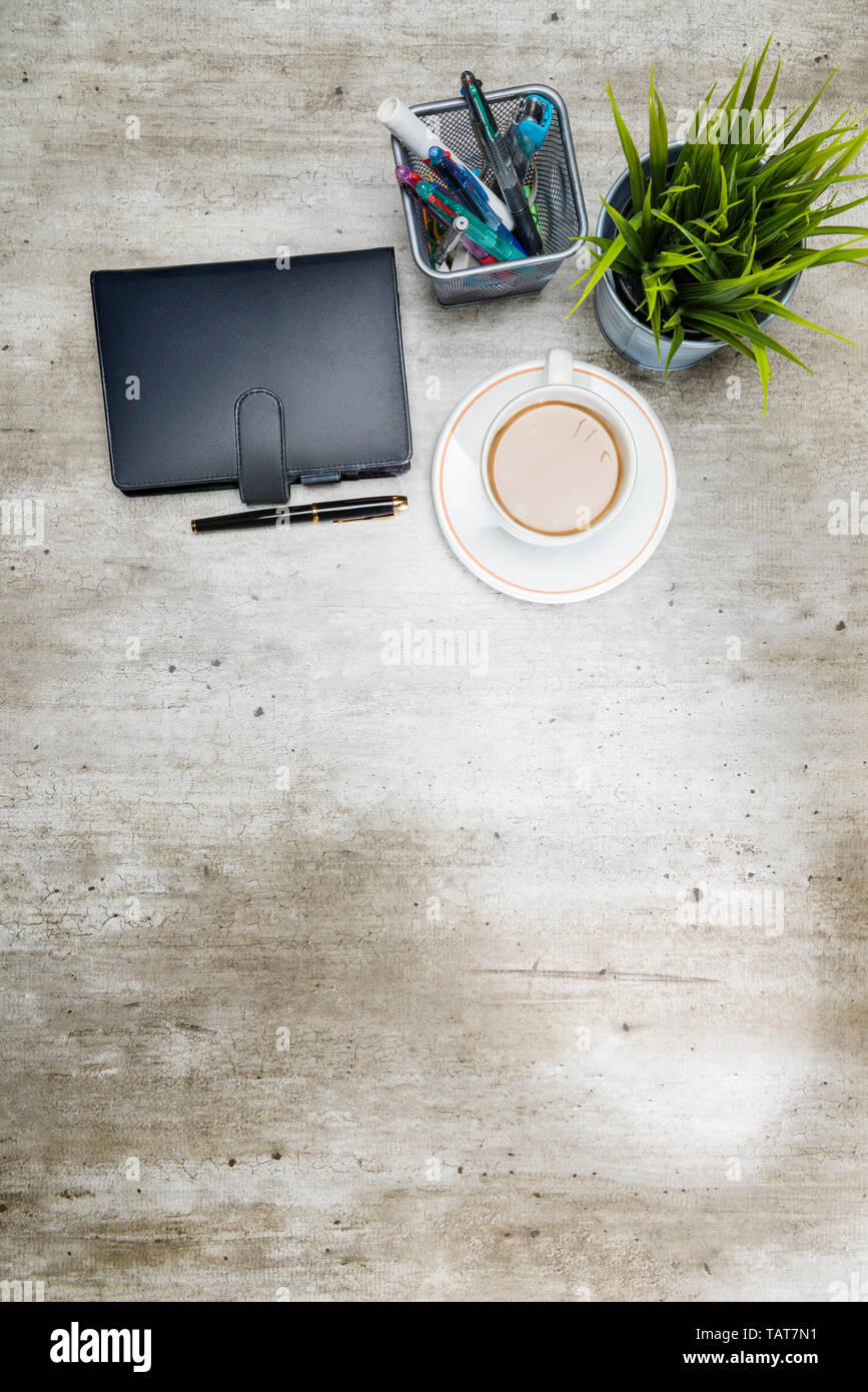 Vista superiore della scrivania business con caffè, pianta in vaso, notebook e accessori business per l'ufficio Foto Stock