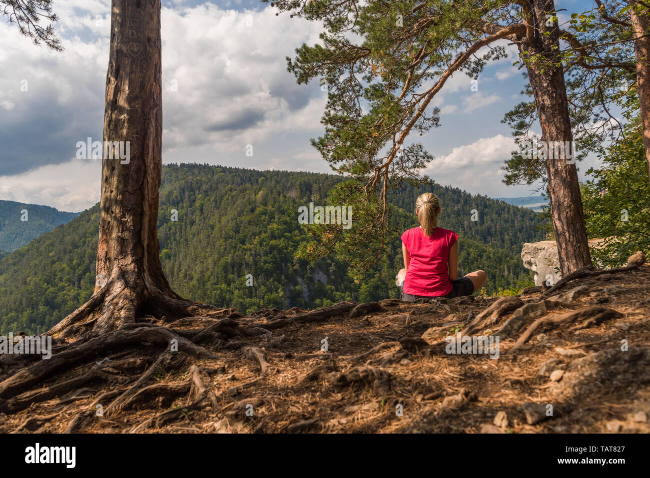 Donna seduta in joga postura cercando sui monti Foto Stock