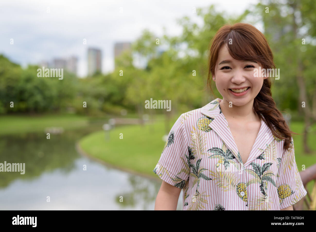Giovane bella asiatica donna turistica rilassante presso il parco Foto Stock