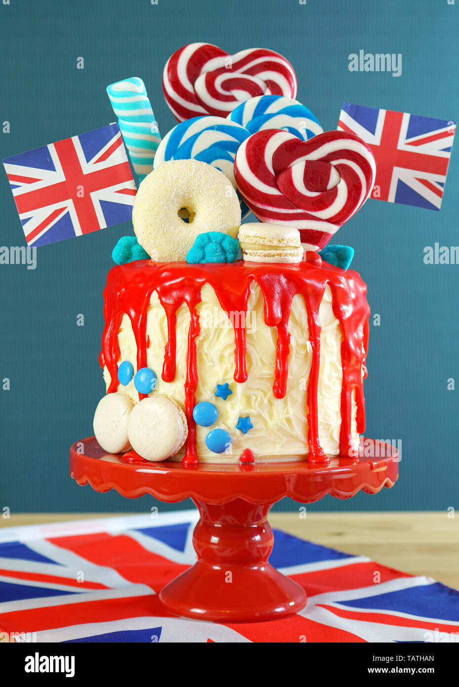 Regno Unito su trend candyland fantasia torta di gocciolamento con rosso, bianco e blu di decorazioni, lecca-lecca e bandiere. Foto Stock