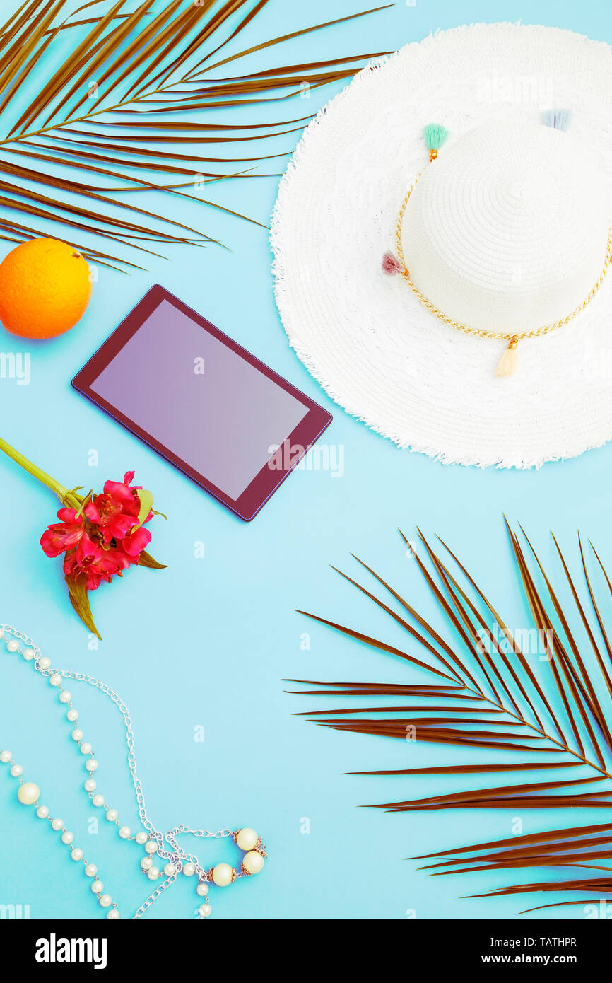 Donna accessori sulla spiaggia con un nero tablet Foto Stock