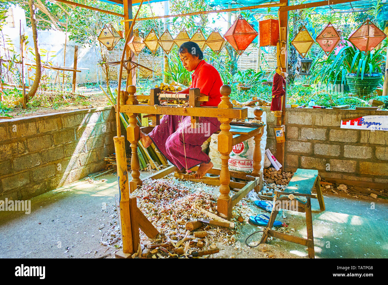 PINDAYA, MYANMAR - 19 febbraio 2018: Il falegname produce le maniglie di bambù per carta ombrelloni, utilizzando azionato a pedale per tornitura in legno tornio in tradit Foto Stock