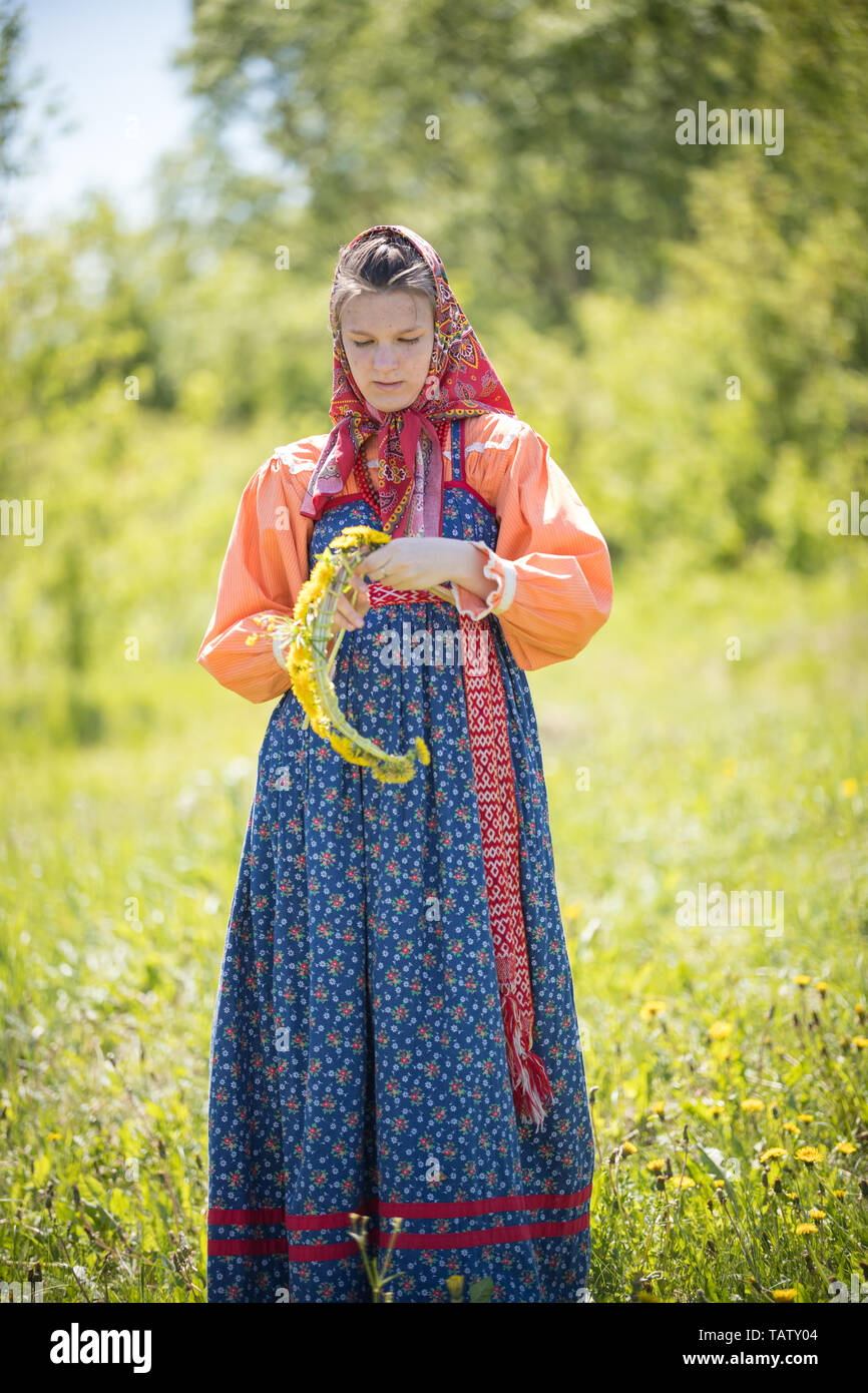 RUSSIA, Nikolskoe village, Repubblica di Tatarstan 25-05-2019: una giovane  donna nel tradizionale russo vestiti rendendo un omaggio floreale. Metà  shot Foto stock - Alamy