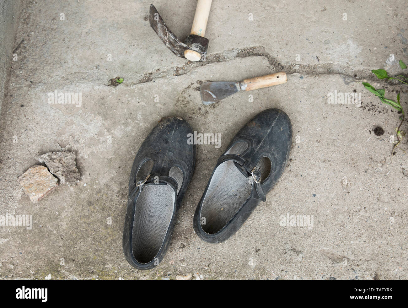 Vecchia gomma sporca patibolo stand sul terreno al di fuori del cemento, galoshi Foto Stock