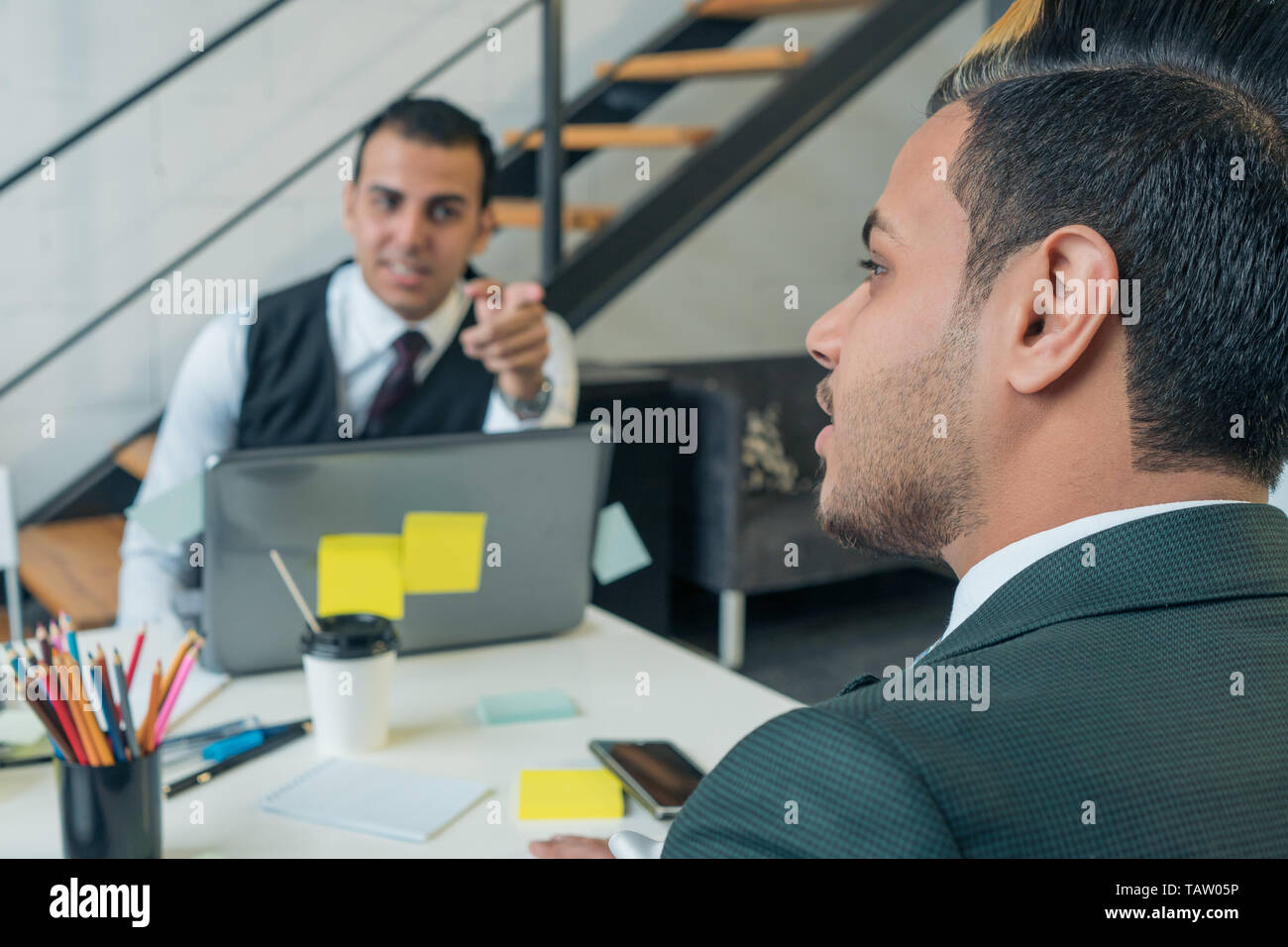 Il giovane uomo è un business conversazione con i colleghi in ufficio. Formazione aziendale. Foto Stock