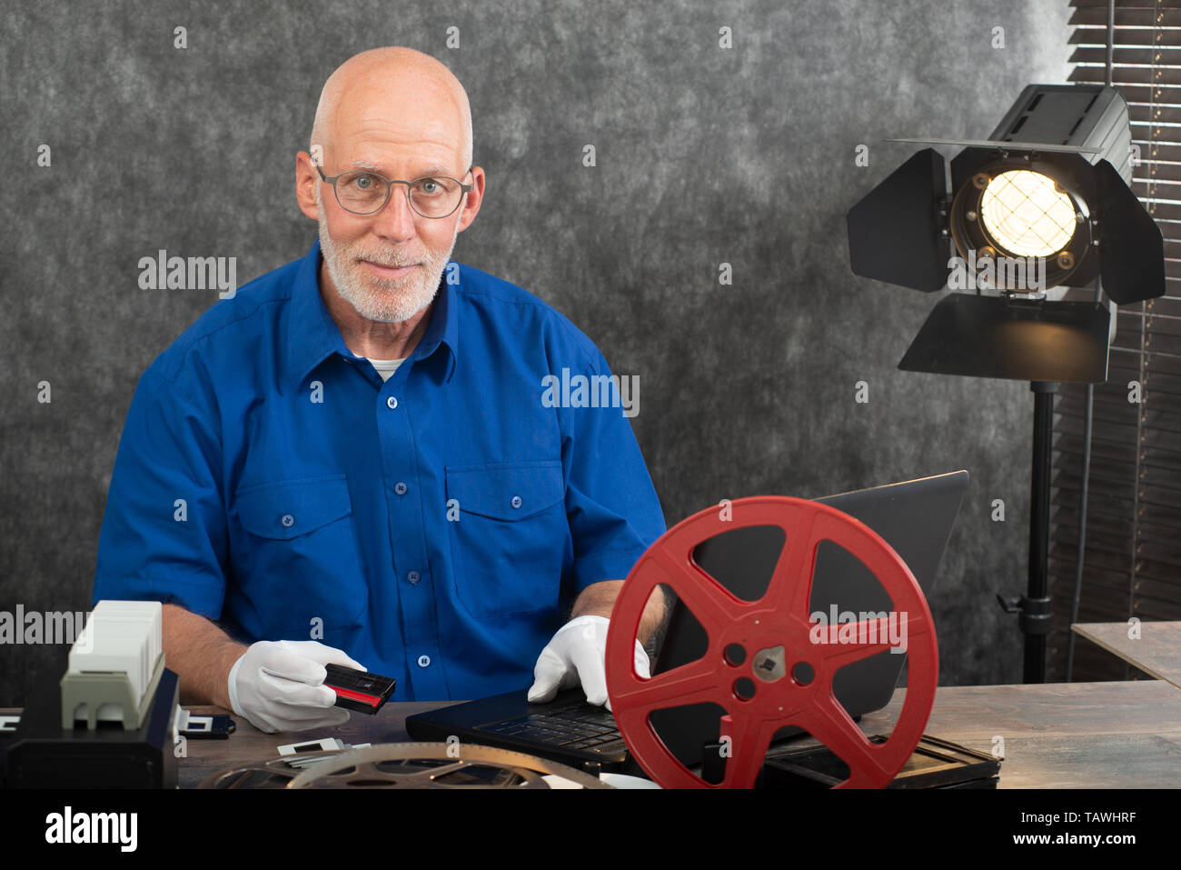 Il tecnico con i guanti bianchi la digitalizzazione di una mini-DV cassette Foto Stock